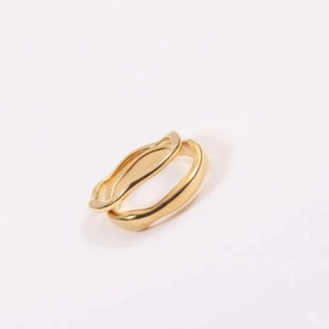Anillo de acero inoxidable dorado minimalista con diseño de ondas y acabado pulido fino