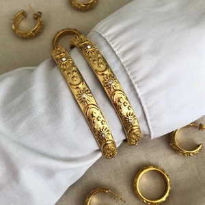 Bracciali rigidi dorati con motivi a rilievo luna e stelle e accenti di zirconi scintillanti