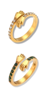 Dettaglio di anelli abbraccio placcati in oro 18K con zirconi chiari e verde smeraldo