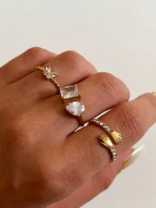 Detail van vier gouden zirkonia ringen met vlinder- en druppelvormig ontwerp
