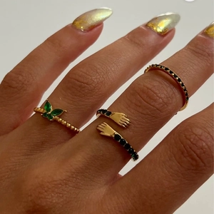 Tre anelli in titanio placcati oro 18K con zircone verde e design a mani intrecciate