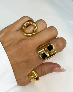 Conjunto de anillos minimalistas de acero inoxidable dorado con piedra negra en la mano