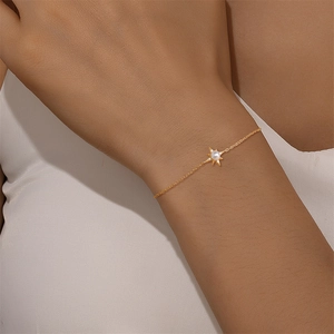 Détail d'un bracelet en argent s925 doré avec une perle dans un pendentif étoile