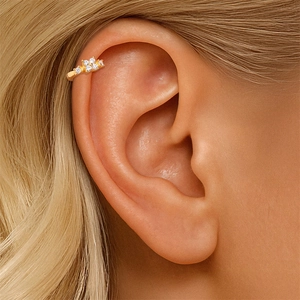 Κοντινή λήψη από επιχρυσωμένο ear cuff με πέντε λευκά αστραφτερά ζιργκόν σε σχήμα λουλουδιού