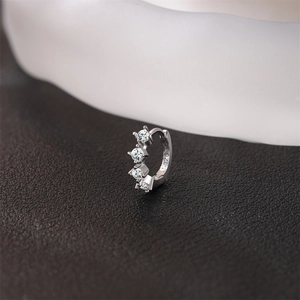 Gros plan sur boucle d'oreille huggie en argent S925 avec zircons blancs ronds