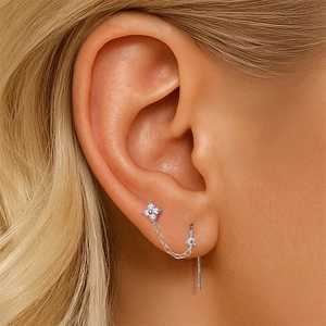Detail showing S925 silver four-leaf petal stud with dangling chain and sparkling moissanite