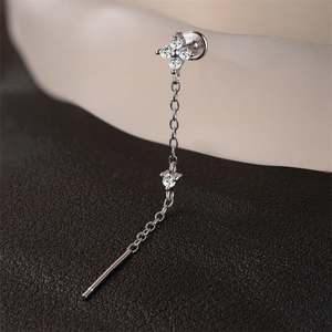Macro shot of silver tassel earring with clover petals and sparkling moissanite stones