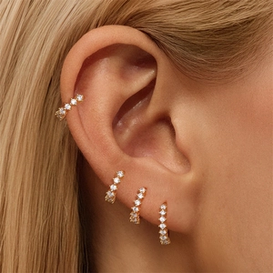 Detailed view of multiple gold S925 sterling silver huggie earrings with cubic zirconia stones