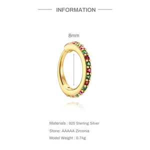 Macro view of gold 925 sterling silver huggie earring with red and green zircons