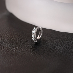Vue macro d'une boucle d'oreille créole en argent S925 avec cinq pierres moissanite