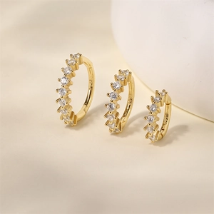 Detail of three gold S925 sterling silver hoop earrings with sparkling zircon stones