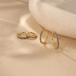 Detail of S925 sterling silver hoop earrings with pink and green stones and gold plating
