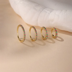 Macro detail of S925 sterling silver hoop earrings with pink and green zircon stones