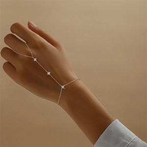 Detail eines s925 Silber-Fingerarmbands mit funkelnden Moissanit-Kleeblatt-Anhängern