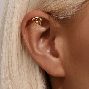 Detalle de piercing de estrella y luna en plata S925 con borlas y cristales