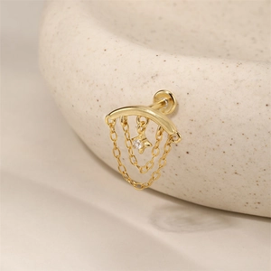 Detalle de pendiente de plata s925 dorado con cadenas de borla y estrella de circon
