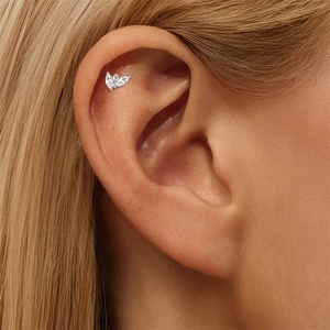 Detail of S925 silver ear stud with marquise-cut zircons worn on the ear cartilage