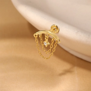 Vista macro de piercing labret en plata dorada con cadenas en capas y colgante de estrella