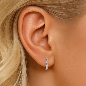 Close-up of S925 sterling silver huggie earrings with sparkling pavé zircons on model