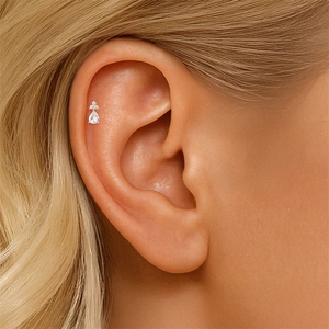 Detailed view of a gold teardrop stud earring with tiny crystals on a helix piercing