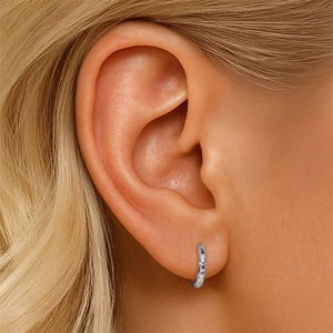 Detailed close-up of a S925 sterling silver earring with star engravings on the earlobe