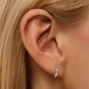 Detailed close-up of S925 sterling silver huggie earrings with engraved star patterns