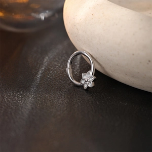 Macro shot of S925 silver flower stud earring with white zircons on dark leather