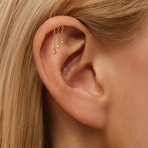 Detailaufnahme des vergoldeten Sterling-Silber-Piercings mit dreifacher Zirkonia-Kette