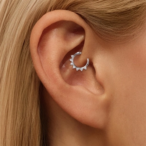 Macro-opname van S925 zilveren bloem moissanite daith piercing ring bij een model