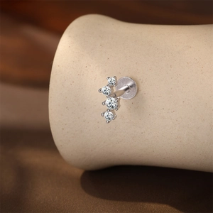 Macro shot of silver stud earring featuring four curved zircon stones on flat back post