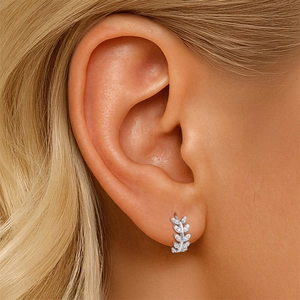 Close-up of S925 silver leaf earrings set with moissanite stones on model's ear