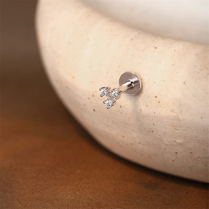 Vista macro de un piercing labret de plata s925 con grupo de tres diamantes