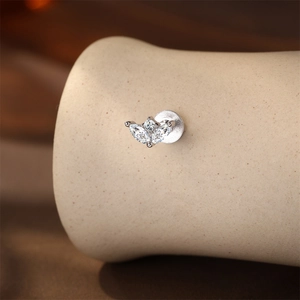 Macro shot of S925 silver stud earring featuring marquise-cut and round moissanite stones