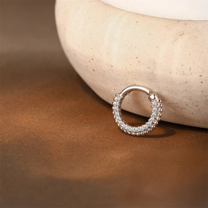 Macro shot of silver hinged clicker with triple-row pavé cubic zirconia inlay