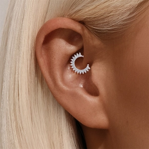 Close-up of S925 sterling silver ear cuff with sun-shaped zirconia crystals on ear