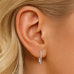 Close-up of sparkling S925 sterling silver hoop earrings with diamonds on ear