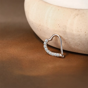 Macro view of heart-shaped S925 sterling silver hoop with eight sparkling inlaid stones