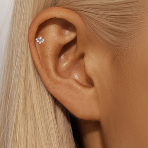 Vista macro detallada del piercing helix de plata S925 con flor de moissanita en la oreja