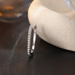 Detail view of S925 sterling silver huggie earring with sparkling pavé cubic zirconia