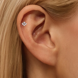 Detalle del pendiente moissanita de plata S925 con diseño de corona en el cartílago helix