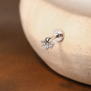 Vista macro detallada de un piercing labret de plata 925 con cinco circonitas brillantes