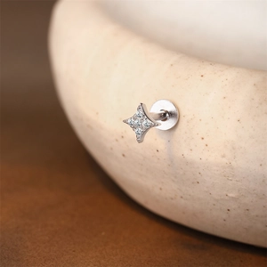 Macro view of a 925 silver four-pointed star labret stud with white cubic zirconia