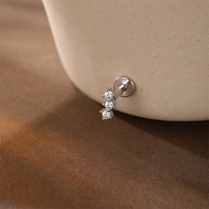 Detalle de un pendiente de plata S925 con tres circonitas brillantes verticales