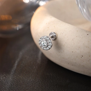 Detalle de pendiente de plata S925 con piedra central y pequeños diamantes brillantes