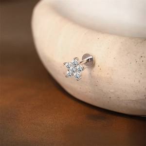 Macro detail of silver flower labret stud with sparkling marquise moissanite petals