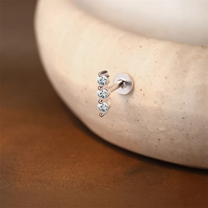 Macro view of triple moissanite labret stud with silver flat back threaded design