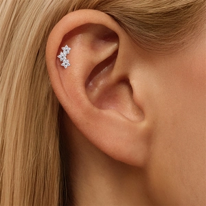 Detalle de pendientes de tres flores en plata S925 con pavé de moissanita brillante
