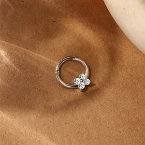 Macro shot of silver S925 sterling silver clicker hoop with sparkling zircon flower detail