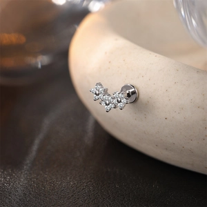 Primer plano de pendiente de plata S925 con flores de moissanita y cierre tipo labret