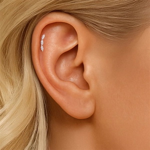 Detalle del piercing de plata S925 con tres piedras de talla marquesa en la oreja